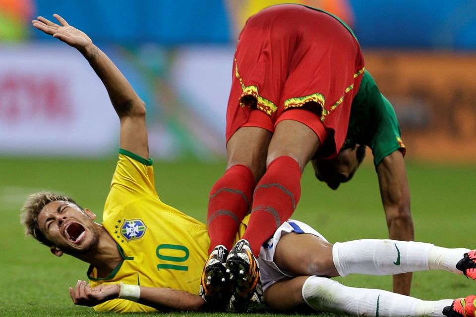 Brazil's Neymar cries in pain after colliding with Cameroon's Joel Matip during the group A World Cup soccer match between Cameroon and Brazil at the Estadio Nacional in Brasilia, Brazil, Monday, June 23, 2014. (AP Photo/Andre Penner)