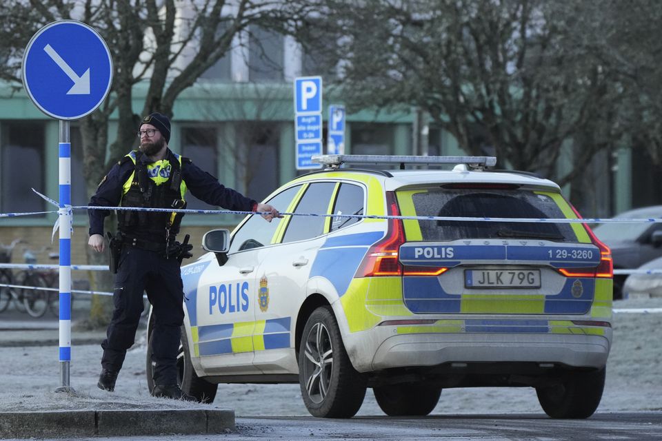 Police guard the scene of a shooting at an adult education centre as Sweden reels from the attack (Sergei Grits/AP)