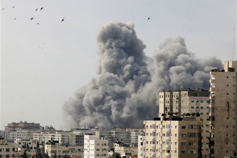 Smoke rises over Gaza City, following an Israeli air strike at the Palestinian police headquarters in Gaza City, Saturday, Dec. 27, 2008. Israeli warplanes retaliating for rocket fire from Gaza pounded dozens of security compounds across the Hamas-ruled territory in unprecedented waves of air strikes Saturday, killing at least 155 and wounding more than 310 in the bloodiest day in Gaza in decades. (AP Photo/Ashraf Amra)