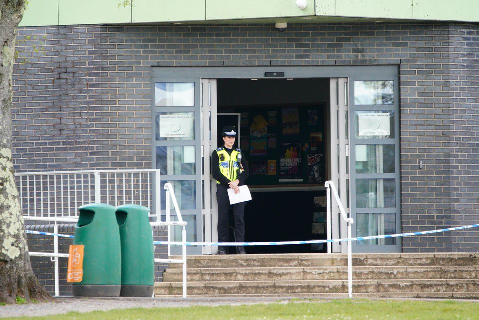 A police officer stands at the entrance to the school in Ammanford, Carmarthenshire, after an arrest was made (Ben Birchall/PA)