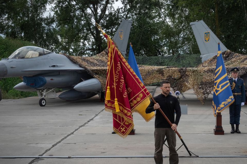 President Volodymyr Zelensky hands over the flag of a military unit (Efrem Lukatsky/AP)