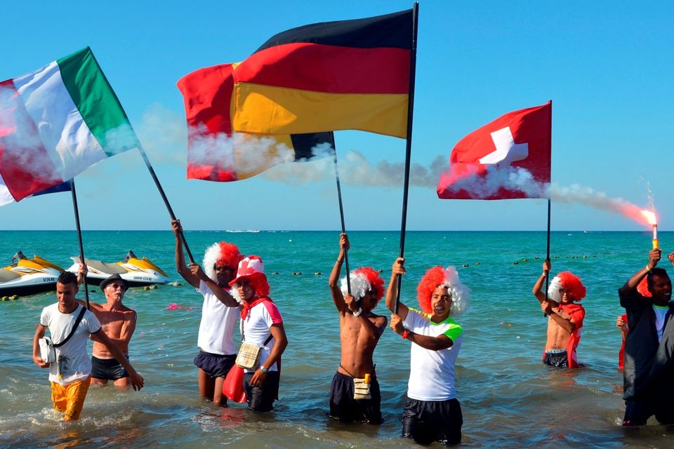 Tourists take part in a gathering in solidarity with Tunisia's tourism industry, on June 29, 2015 on the island of Djerba, following a deadly gun attack at a holiday resort near Sousse. Tunisia said it had made its first arrests after a beach massacre on June 26 that killed 38 people, as European officials paid tribute to victims of the country's worst jihadist attack. AFP PHOTO / FETHI NASRIFETHI NASRI/AFP/Getty Images