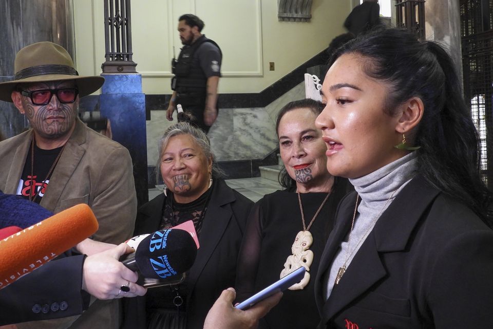 Hana-Rawhiti Maipi-Clarke, right, and her colleagues from Te Pati Maori, talk to reporters following a protest inside parliament in Wellington, New Zealand (Charlotte Graham-McLay/AP)