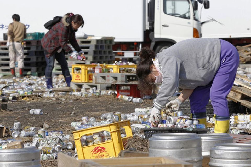 People put away cans containing beer and juice swept out from a beer factory in Sendai, Miyagi Prefecture, northern Japan, Sunday, March 13, 2011, two days after a powerful earthquake and tsunami hit the country's east coast. (AP Photo/Kyodo News) JAPAN OUT, MANDATORY CREDIT, NO SALES IN CHINA, HONG  KONG, JAPAN, SOUTH KOREA AND FRANCE