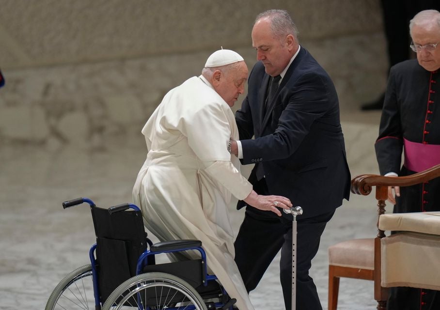 Pope Francis is helped by his assistant Piergiorgio Zanetti as he arrives for his weekly general audience in the Paul VI Hall at the Vatican on Wednesday (Alessandra Tarantino/AP)