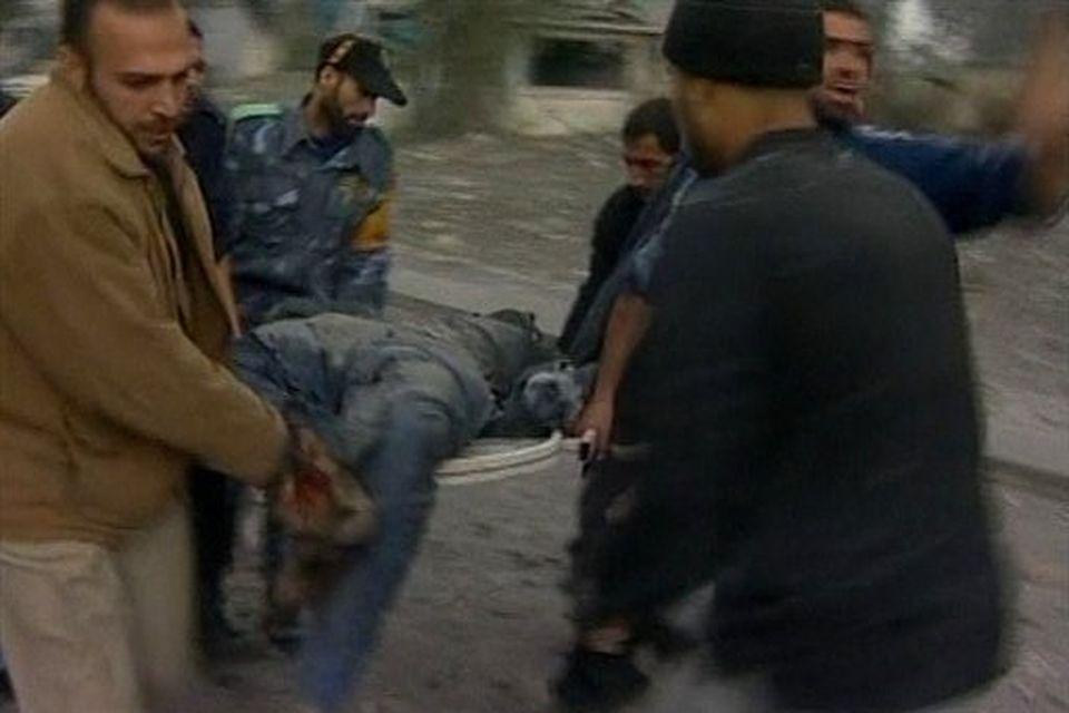 In this image taken from APTN video young men carry a badly injured man on a stretcher to an awaiting vehicle after Israeli aircraft struck Hamas security compounds across Gaza in Gaza City on Saturday Dec. 27, 2008. Hamas and medics reported that dozens of people were killed and that others were still buried under the rubble. The strikes caused widespread panic and confusion, as black clouds of smoke rose above Gaza. (AP Photo/APTN)