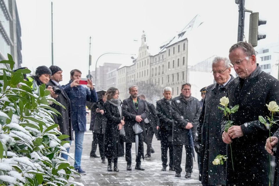 Munich bishop Reinhard Marx, centre, Markus Soeder, prime minister of Bavaria, German president Frank-Walter Steinmeier and Dieter Reiter, mayor of Munich, lay flowers at the site where a car crashed into a demonstration (Ebrahim Noroozi/AP)