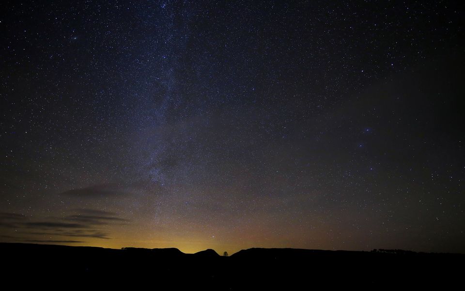 Stars and the Northern Lights are seen above the Sycamore Gap tree (Owen Humphreys/PA)