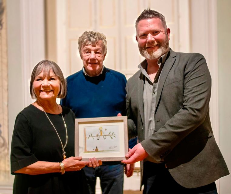 Lord and Lady Dunleath being presented with a signed illustration by Philip Johnston