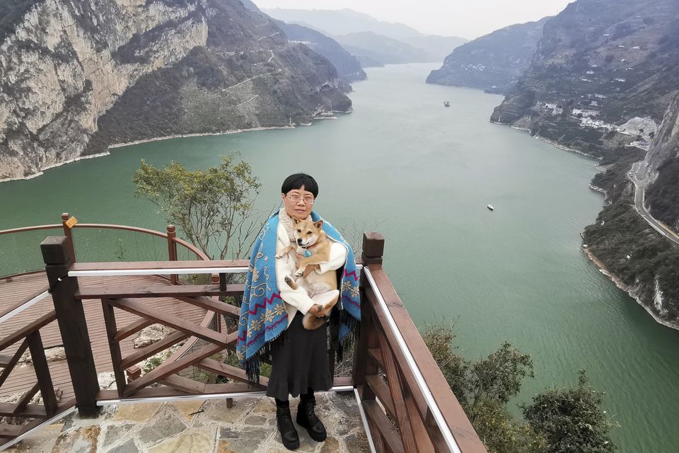 Zhang Yali poses with her dog Little Cotton (Tan Yuanyi via AP)