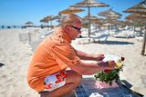 thumbnail: SOUSSE, TUNISIA - JUNE 27:  A man places flowers at the beach next to the Imperial Marhaba Hotel where 38 people were killed yesterday in a terrorist attack on June 27, 2015 in Souuse,Tunisia. Habib Essid Prime Minister of Tunisia  announced a clampdown on security after the attack on a holiday resort..  (Photo by Jeff J Mitchell/Getty Images)