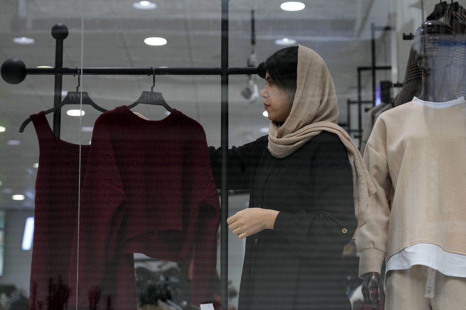 A shopkeeper puts on a woman’s clothes on a mannequin at a shop in port city of Bandar Anzali in northern Iran (Vahid Salemi/AP)