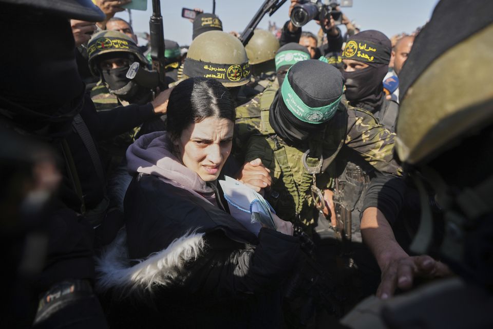 Israeli soldier Arbel Yehoud is escorted by Hamas and Islamic Jihad fighters as she is handed over to the Red Cross in Khan Younis (AP Photo/Abdel Kareem Hana)