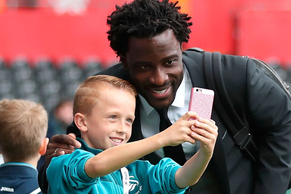 The beautiful game - football fans from around the world -  Swansea City's Wilfried Bony takes a picture with a young fan prior to the Premier League match at the Liberty Stadium, Swansea.