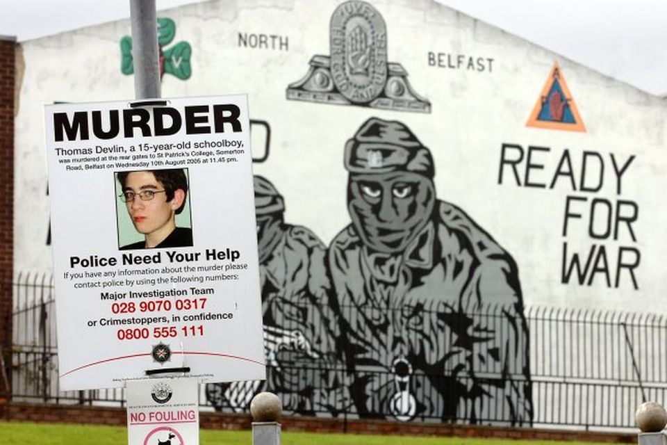 A Thomas Devlin murder appeal poster beside a UVF (Ulster Volunteer Force) mural in the Mount Vernon area of North Belfast opposite the flats where one of his killers had lived.
