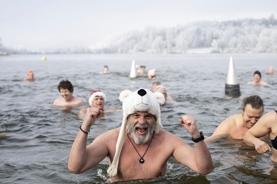 Swimmers attend the traditional New Year’s Eve swimming at Lake Moossee in Moosseedorf, Switzerland (Anthony Anex/Keystone via AP)