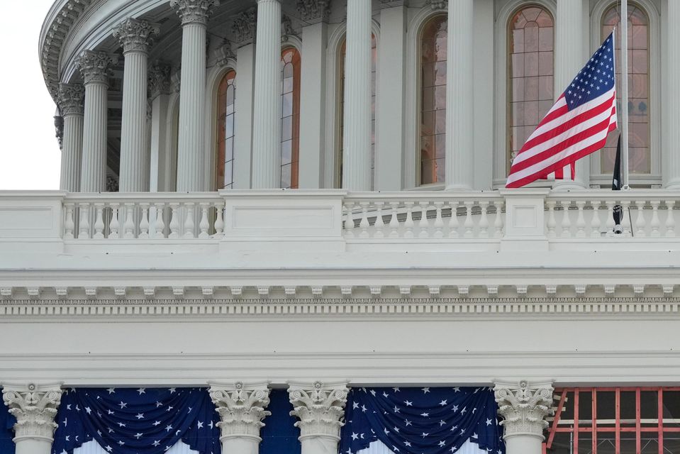 US flags hang from the Capitol ahead of President-elect Donald Trump’s upcoming inauguration (Jon Elswick/AP)