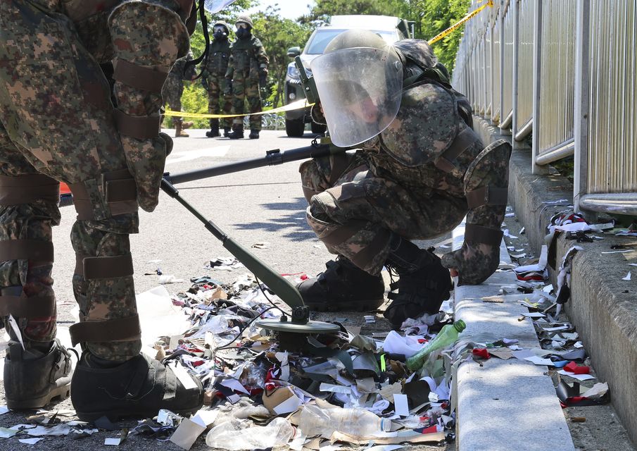 South Korean soldiers wearing protective gears check the trash from a balloon (Im Sun-suk/Yonhap via AP)