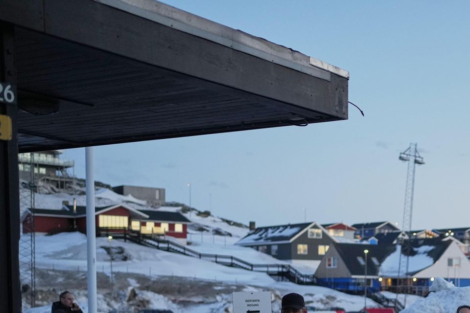 People line up outside a polling station to cast their vote in parliamentary elections in Nuuk, Greenland (Evgeniy Maloletka/AP)