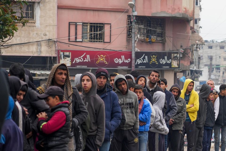 Palestinians queue to purchase bread outside a bakery in Gaza City (Abdel Kareem Hana/AP)