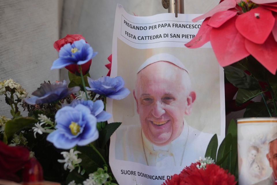 Candles and a photo of Pope Francis are seen in front of the hospital (Alessandra Tarantino/AP)