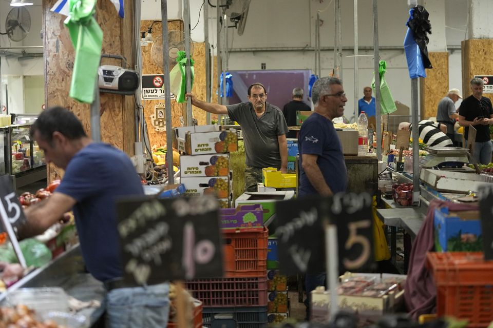 Vendors sell fruit and vegetables in a market in Haifa, Israel (Ohad Zwigenberg/AP)