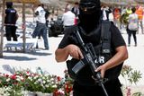 thumbnail: A hooded Tunisian police officer stands guard ahead of the visit of top security officials of Britain, France, Germany and Belgium at the scene of Friday's shooting attack in front of the Imperial Marhaba hotel in the Mediterranean resort of Sousse, Tunisa, Monday, June 29, 2015. The top security officials of Britain, France, Germany and Belgium are paying homage to the people killed in the terrorist attack on Friday. (AP Photo/Abdeljalil Bounhar)