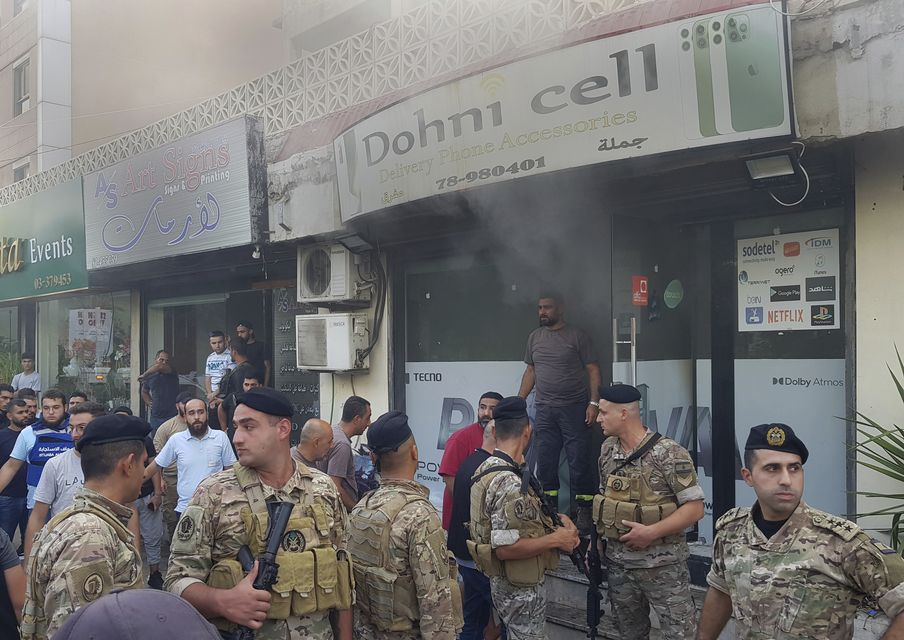 Lebanese soldiers gather outside a damaged mobile shop after what is believed to be the result of a walkie-talkie exploding inside it, in the southern port city of Sidon, Lebanon, (Mohammed Zaatari/AP)