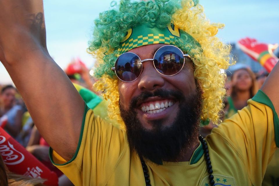 RIO DE JANEIRO, BRAZIL - JUNE 23:  Brazilian soccer fans react to their team scoring their 1st goal against Cameroon while watching on a screen at the FIFA Fan Fest on Copacabana beach June 23, 2014 in Rio de Janeiro, Brazil.  (Photo by Joe Raedle/Getty Images)