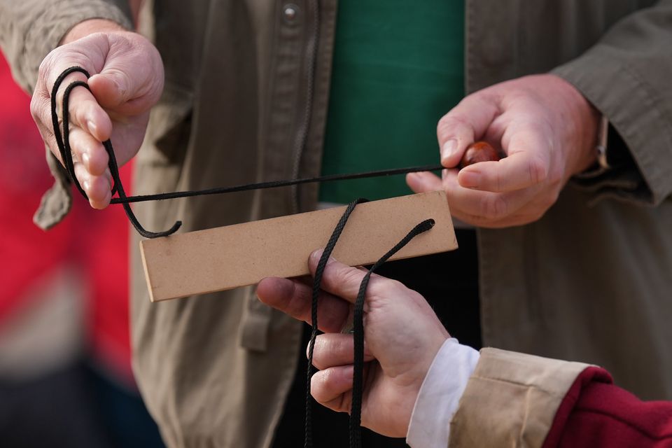 Conker string is measured as competitors take part in the annual World Conker Championships. (Jacob King/PA)