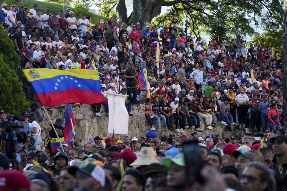 Government supporters rally in defence of president Nicolas Maduro’s re-election outside Miraflores presidential palace in Caracas, Venezuela (Fernando Vergara/AP)