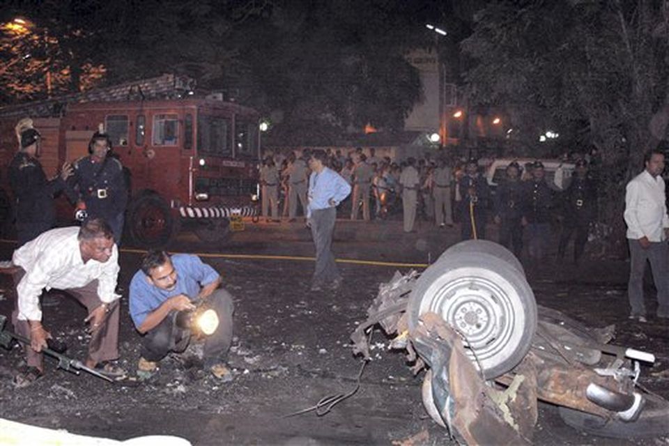 Police examine a damaged vehicle at the site of an explosion in Mumbai, India's financial capital,  on Wednesday evening. Teams of heavily armed gunmen stormed luxury hotels, a popular restaurant, hospitals and a crowded train station in coordinated attacks across India's financial capital Wednesday night, killing at least 78 people and taking Westerners hostage, police said. (AP Photo)