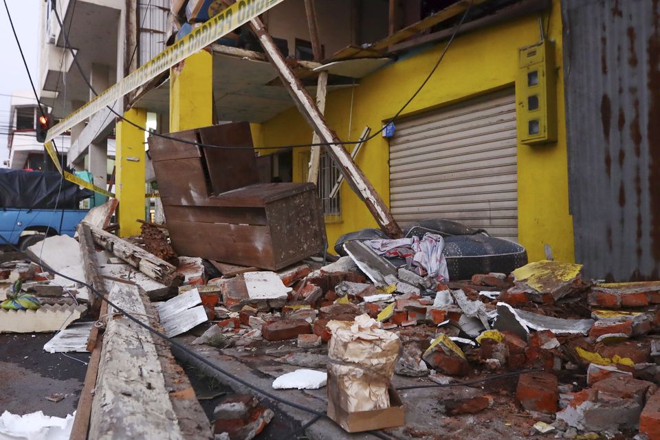 Debris from collapsed homes are scattered on a street after an earthquake shook Machala, Ecuador (Cesar Munoz/AP)