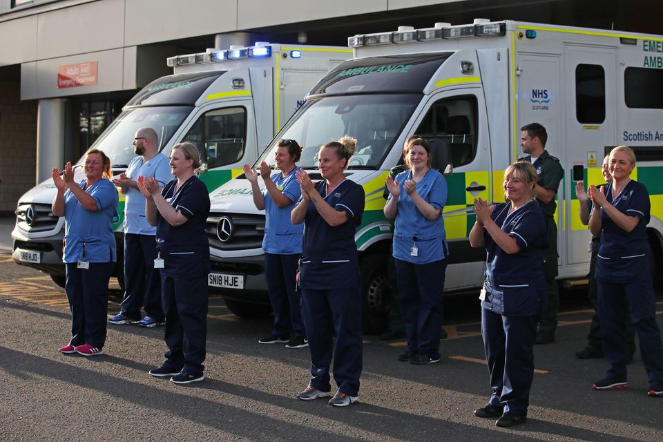 Staff from Queen Elizabeth University Hospital in Glasgow gather as they join in the applause during a nationwide Clap for Carer (PA)