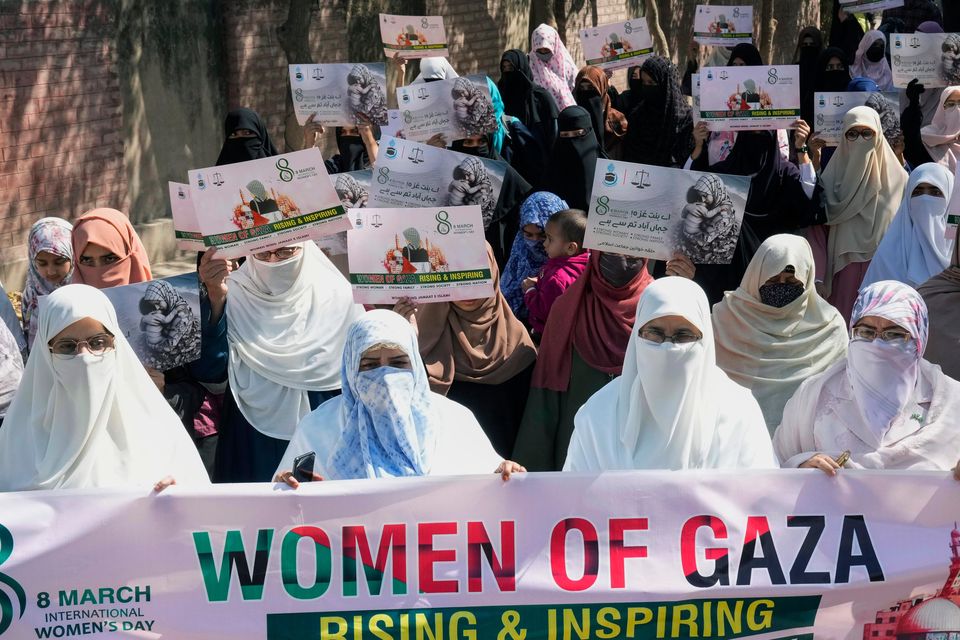 Women supporters of a religious party ‘Jamaat-e-Islami’ hold placards in support of women of Gaza during a demonstration to mark International Women’s Day, in Lahore (AP)