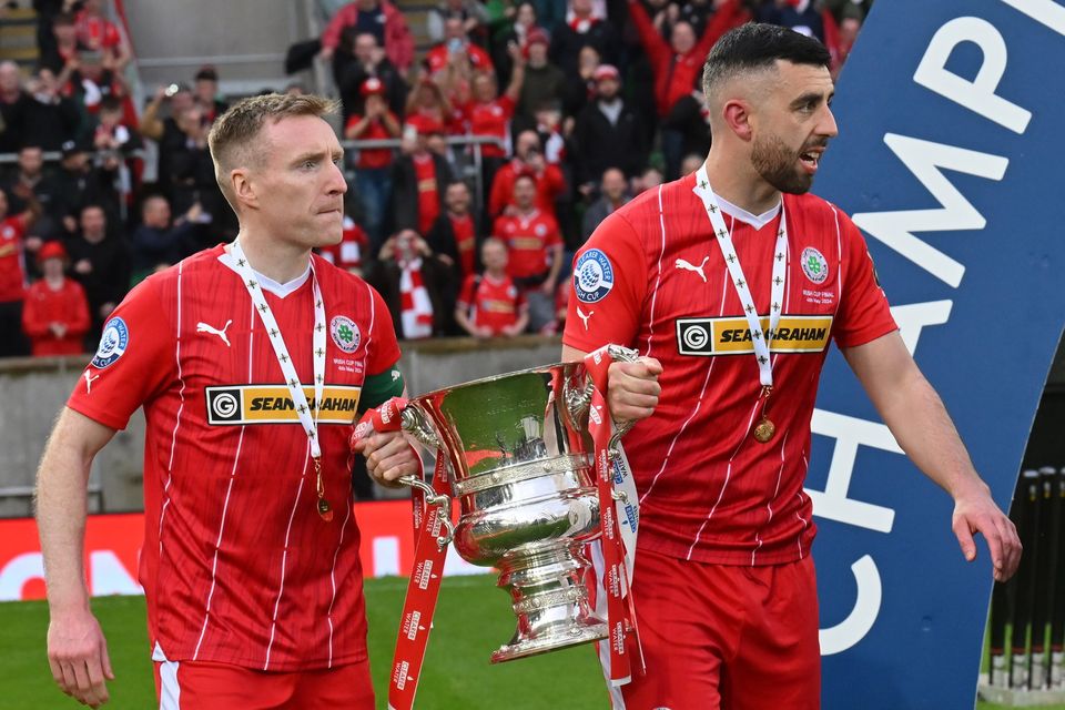Cliftonville legends Chris Curran and Joe Gormley hold the Irish Cup after the victory over Linfield