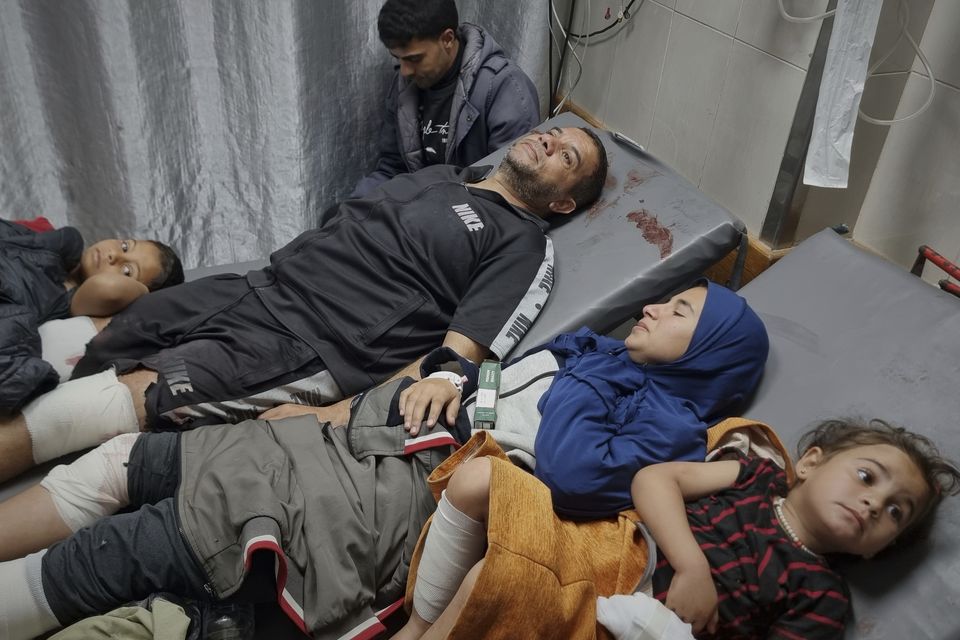 Injured Palestinians wait for treatment at the hospital following Israeli army airstrikes in Khan Younis, southern Gaza Strip (Mohammad Jahjouh/AP)