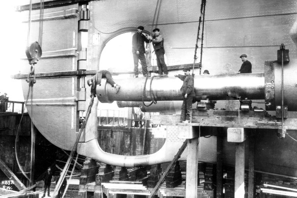 Shipyard men fitting the starboard tailshaft of the Titanic prior to her launch. Photograph © National Museums Northern Ireland. Collection Harland & Wolff, Ulster Folk & Transport Museum