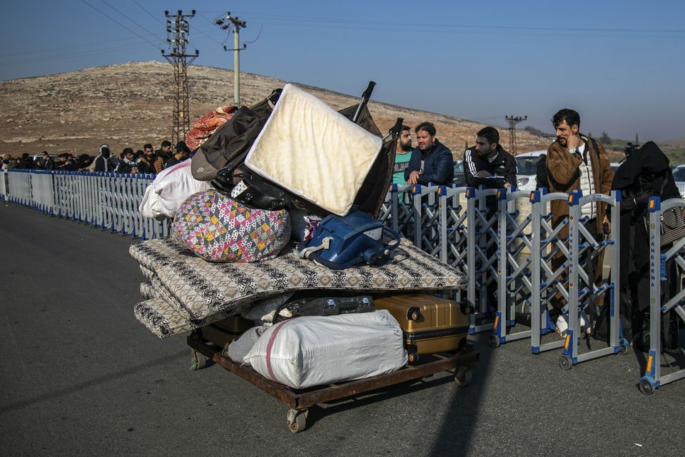 Syrians wait to cross into Syria from Turkey at the Cilvegozu border gate, near the town of Antakya, southern Turkey (Metin Yoksu/AP)