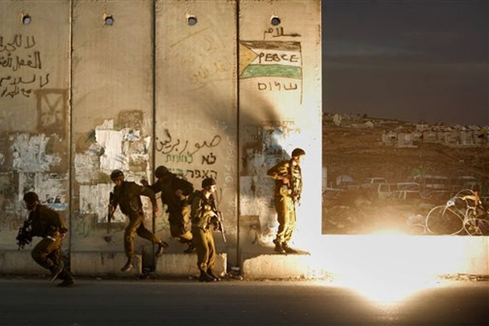Israeli soldiers run away to avoid a stun grenade thrown by another soldier by mistake during clashes with Palestinians, following a demonstration against the Israeli missiles strike on Gaza, at the Kalandia checkpoint between the West Bank city of Ramallah and Jerusalem Saturday, Dec. 27, 2008. Israeli warplanes attacked dozens of security compounds across Hamas-ruled Gaza on Saturday in unprecedented waves of air strikes. Gaza medics said at least 145 people were killed and more than 310 wounded in the single deadliest day in Gaza fighting in recent memory. (AP Photo/Muhammed Muheisen)