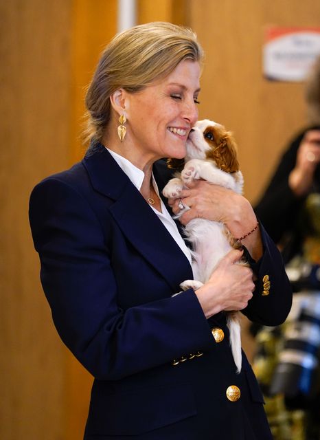 Sophie cuddles puppy Lord Louis of Spudringham during a visit to Dogs for Autism (Andrew Matthew/PA)