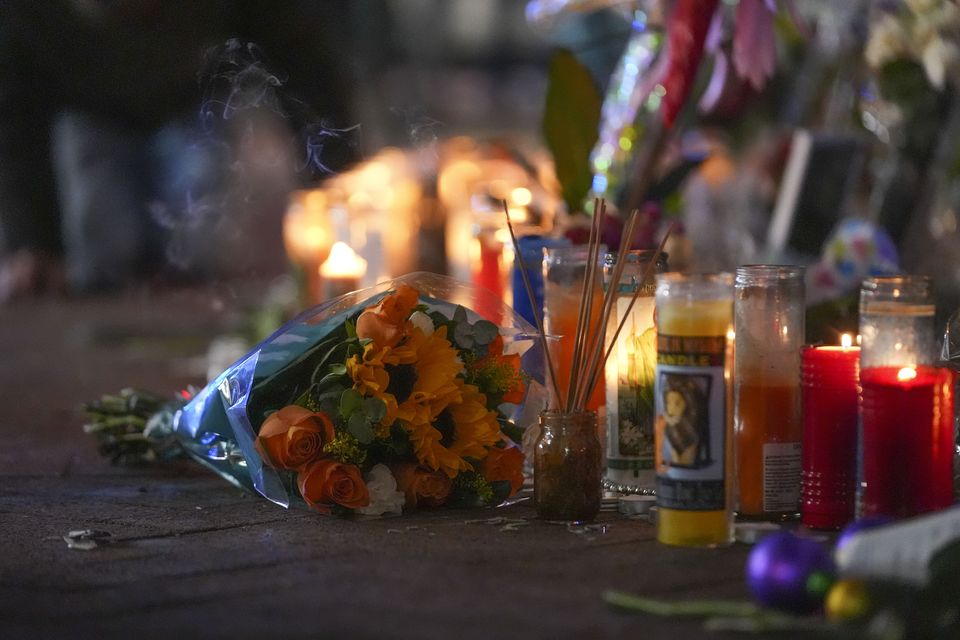 Flowers lie next to candles at a memorial for the victims of the attack (Gerald Herbert/AP)