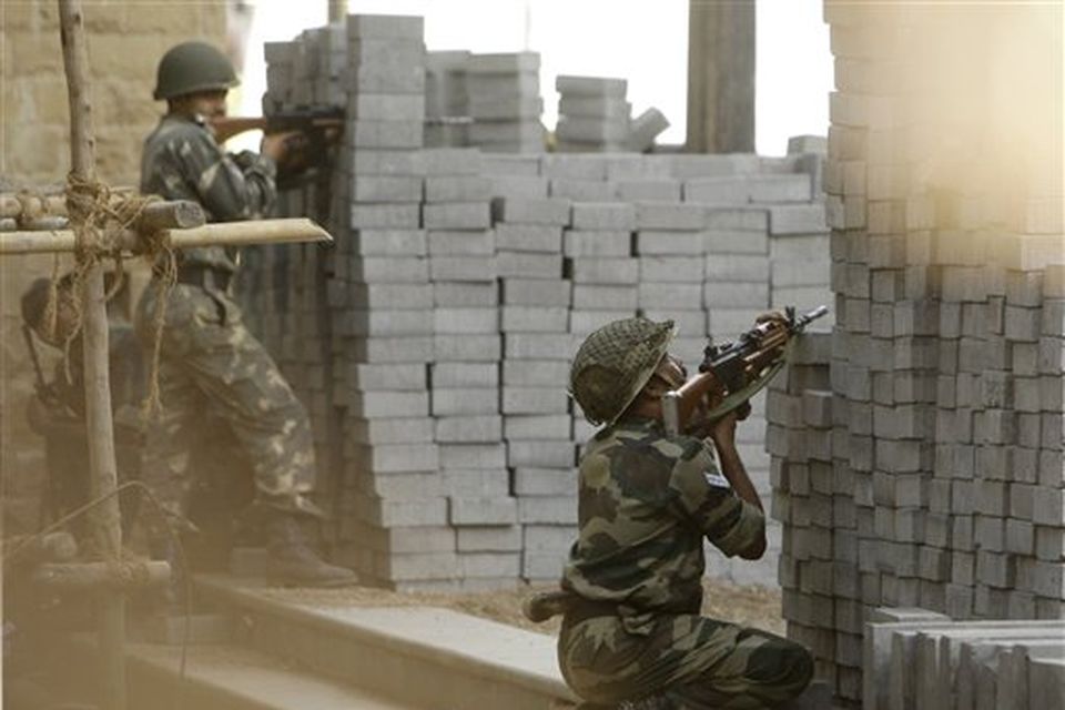 Indian army soldiers take up positions near the Taj Mahal hotel in Mumbai, India, Thursday, Nov. 27, 2008. Black-clad Indian commandos raided two luxury hotels in the city, to try to free hostages Thursday, and explosions and gunshots shook India's financial capital a day after suspected Muslim militants killed people. (AP Photo/Gurinder Osan)