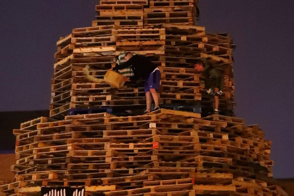 A man lights an 11th night Bonfire in the Sandy Row area of Belfast.  PRESS ASSOCIATION Photo. Picture date: Thursday July 12, 2018. Hundreds of bonfires were set to be lit at midnight as part of a loyalist tradition to mark the anniversary of the Protestant King William's victory over the Catholic King James at the Battle of the Boyne in 1690. See PA story ULSTER Bonfires. Photo credit should read: Niall Carson/PA Wire