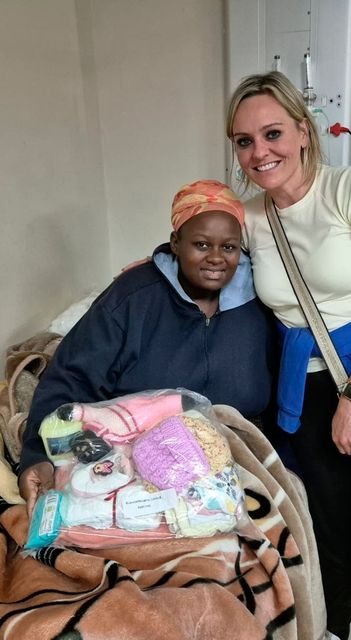 Ruth Gorman hands over pack of useful items to a new mum during her trip