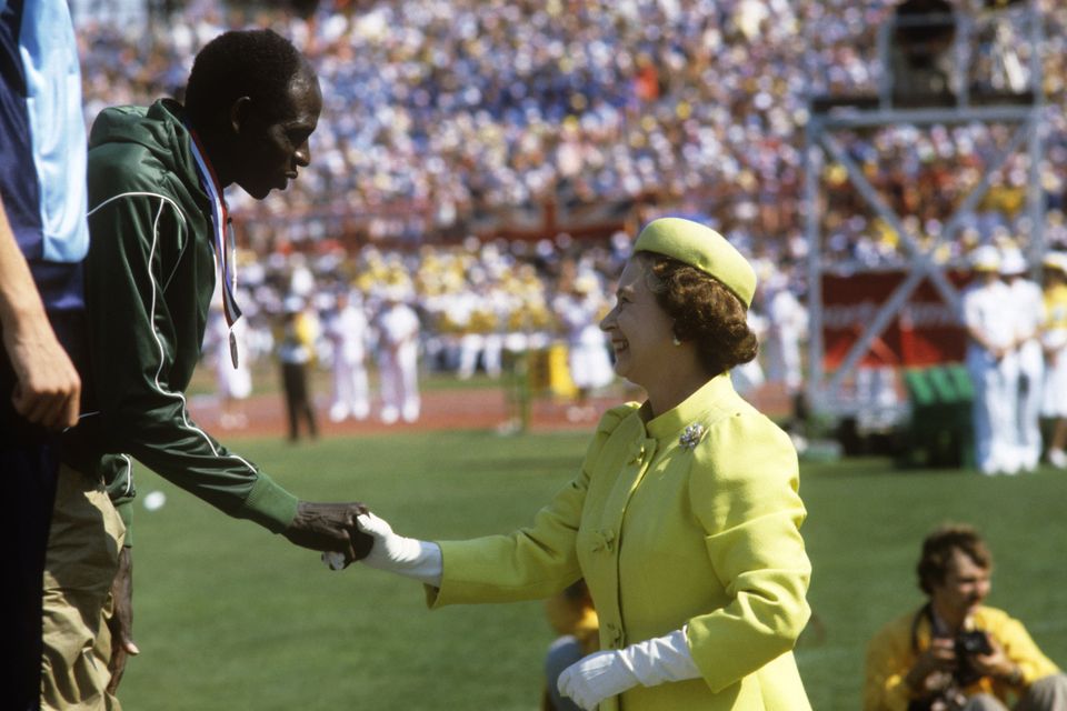 Queen Elizabeth II congratulates one of the athletes during a medal ceremony at the 1982 Commonwealth Games in Brisbane (Ron Bell/PA)