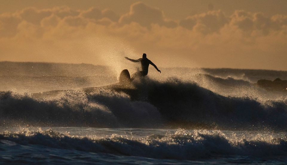 A surfer at Tynemouth Longsands beach on the North East coast (Owen Humphreys/PA)