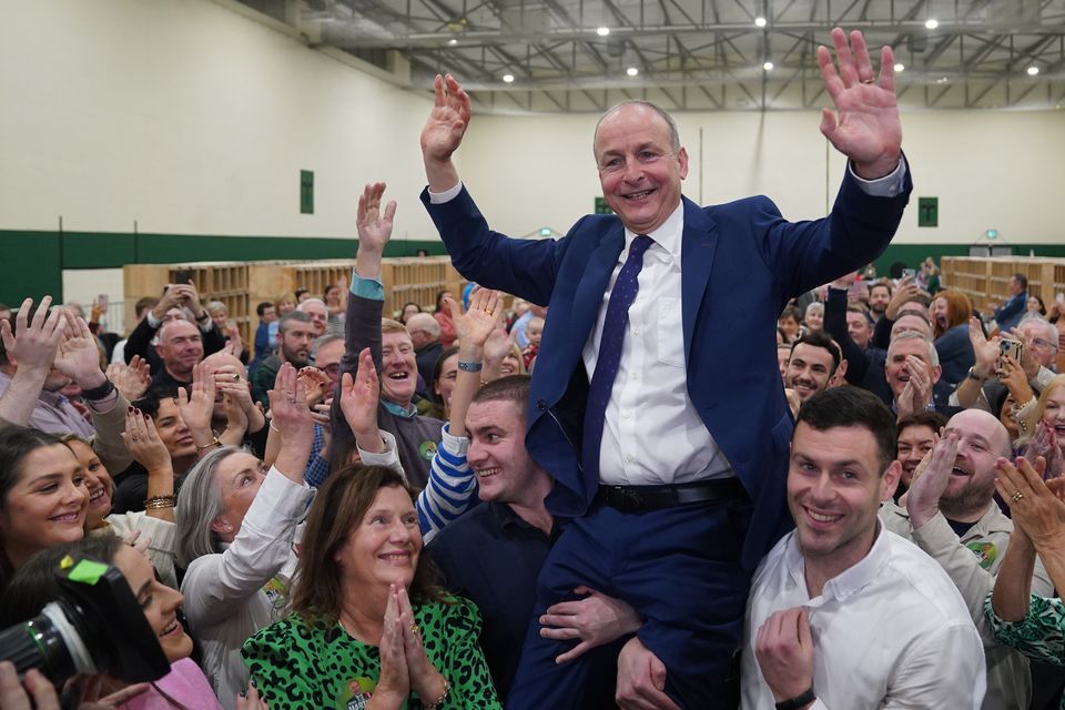 Fianna Fail leader Micheal Martin is hoisted up by his sons Cillian and Micheal Aodh after he was deemed elected in the Cork South Central constituency on Saturday (Jacob King/PA)