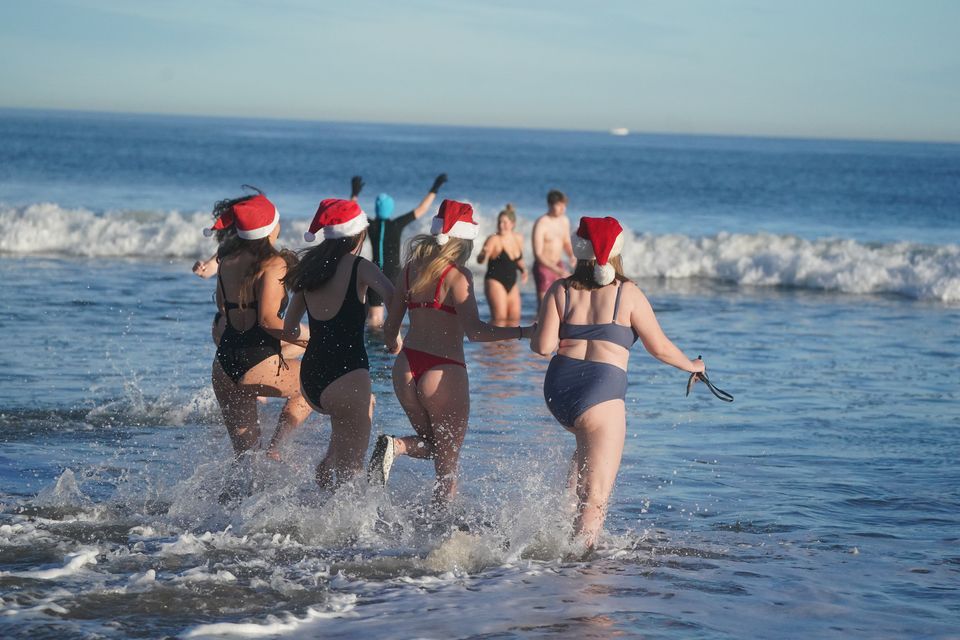 Swimmers wearing Father Christmas hats braved the chilly water for the Boxing Day dip on Tynemouth beach (Owen Humphreys/PA)