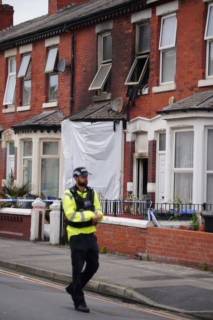 A police officer at a house in Blackpool after a fire which killed a man and a woman (Peter Byrne/PA)